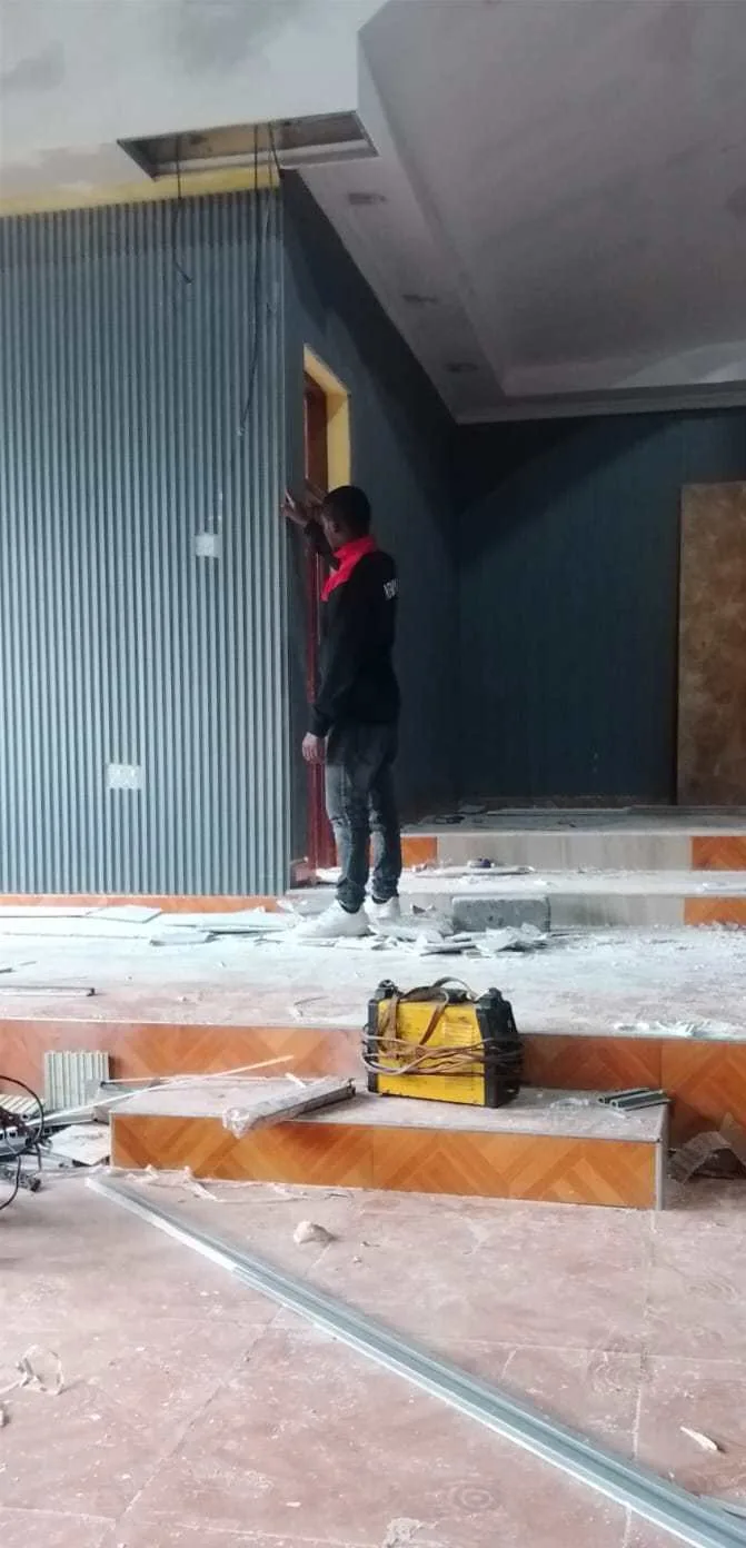 Technician installing tall wall panels on the stage wall