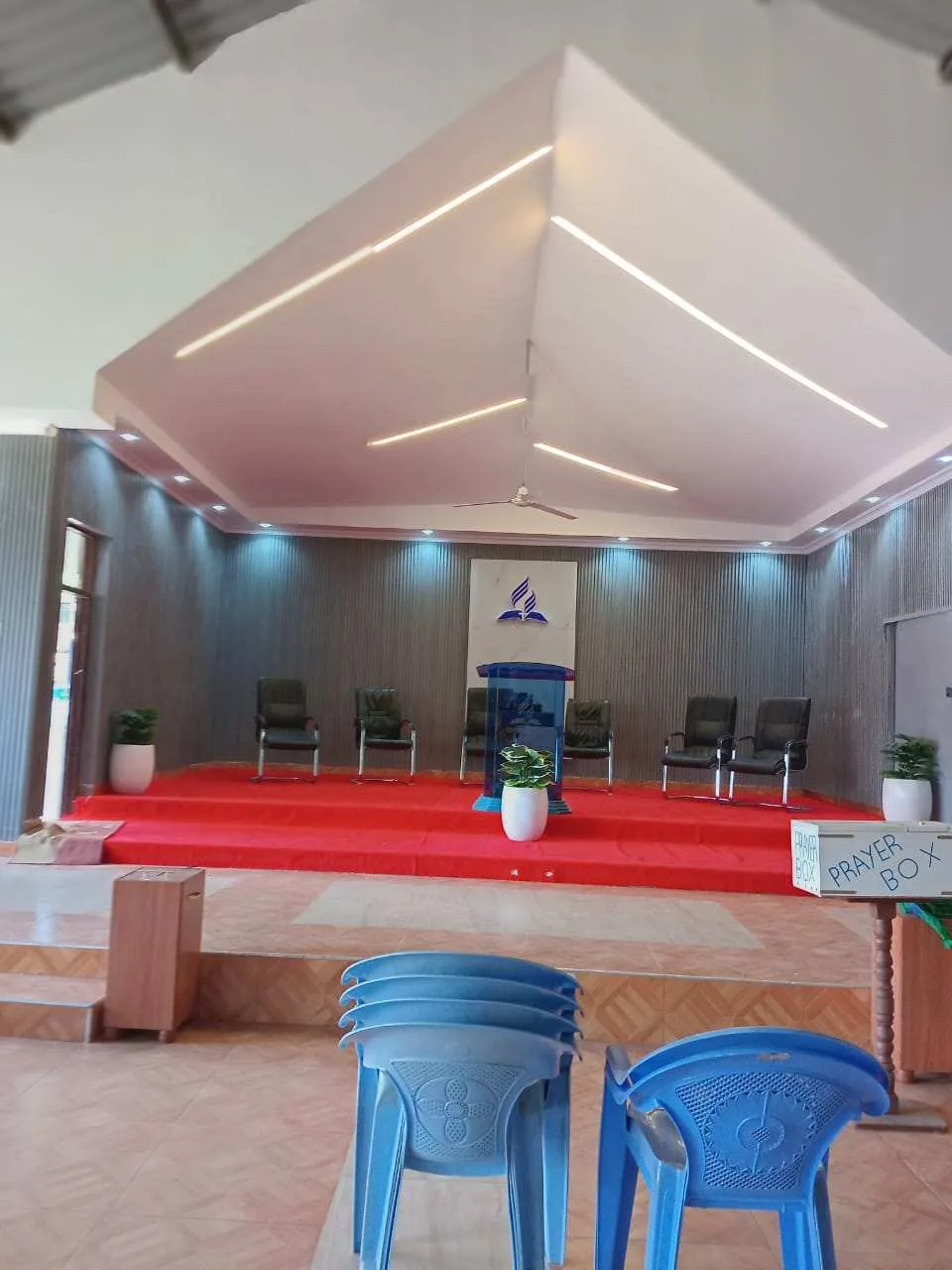 After: finished church stage with podium, LED-lit ceiling and red carpet