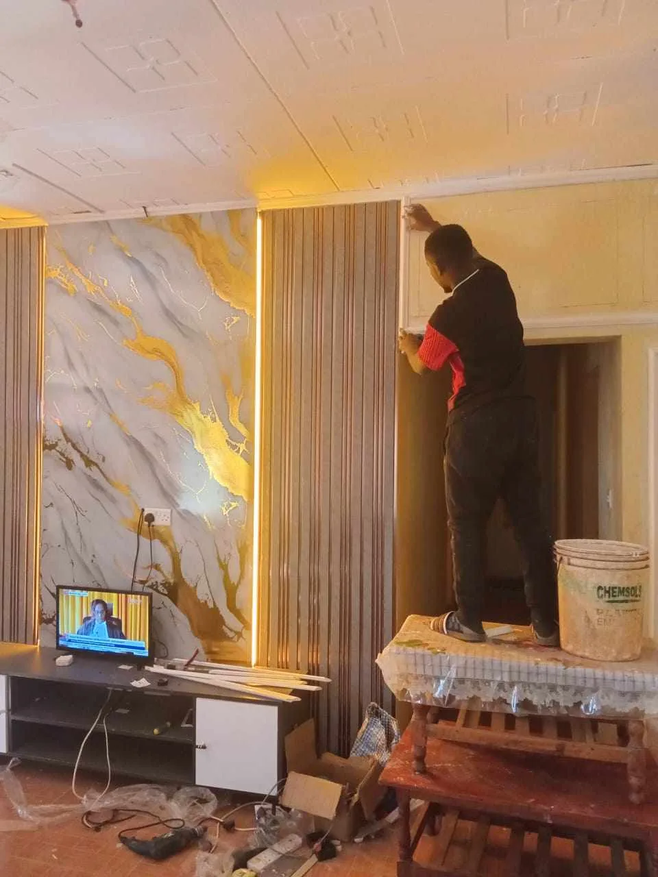 Technician applying finishing touches to the marble and gold wall