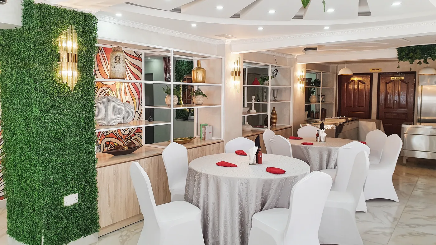 Restaurant dining room with layered lighting and planting, Ruaka