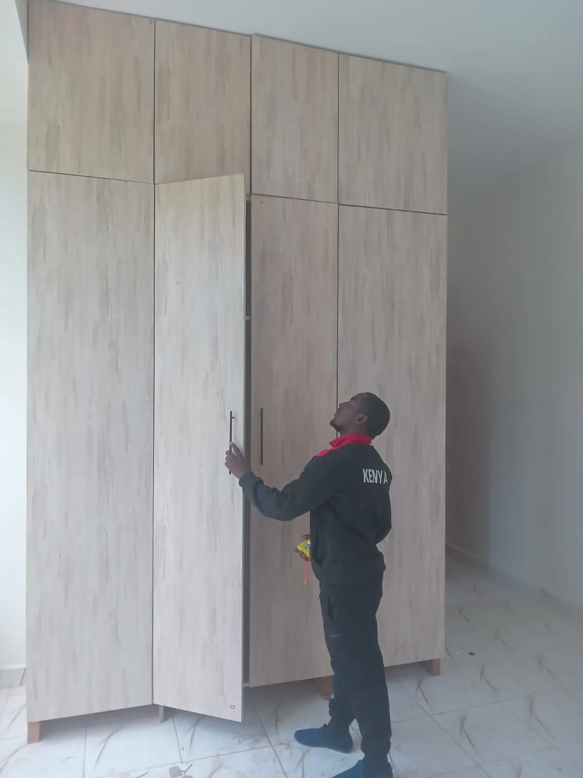 Before: installer hanging wardrobe doors on a fitted unit