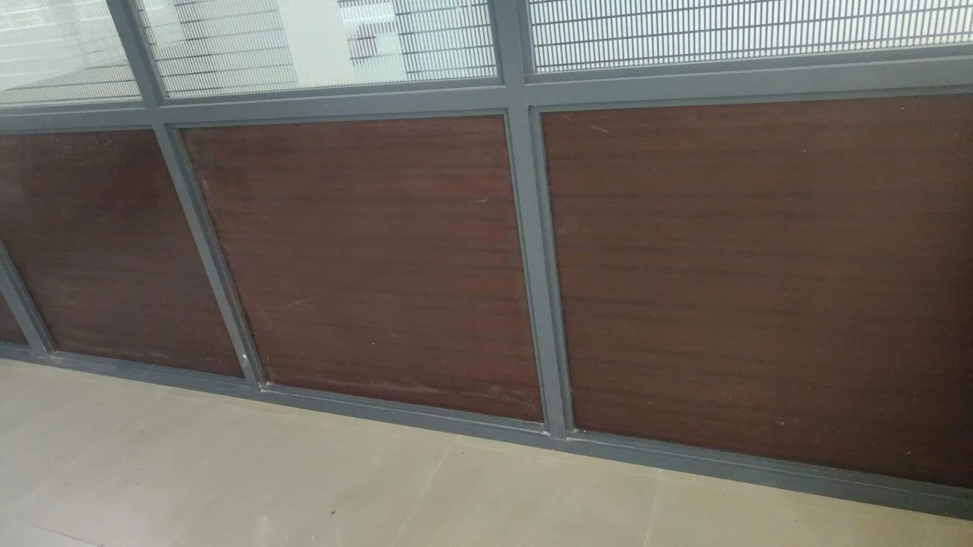 Aluminium-framed glass partitions with timber infill panels across an office floor
